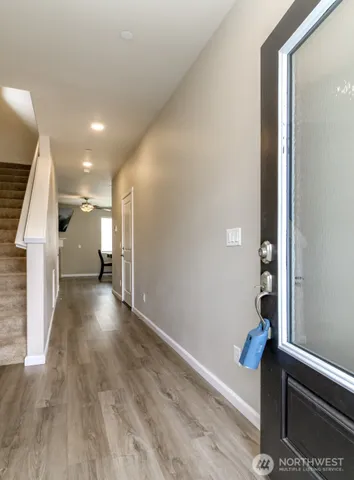 a view of a hallway with wooden floor and staircase