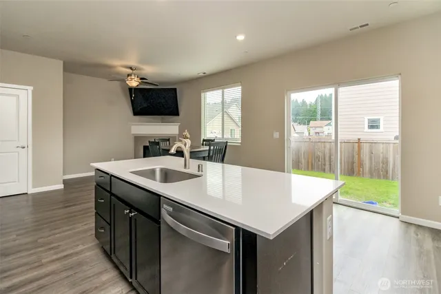 a kitchen with a sink a large window and wooden floor