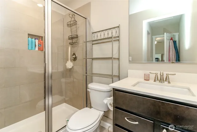 a bathroom with a sink a toilet and shower