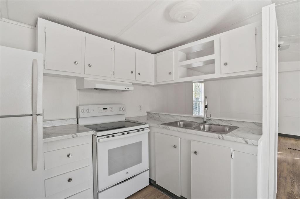 9342 Labelle Street New Port Richey, FL 34654 - Photo 5 of 20 a kitchen with white cabinets appliances and sink
