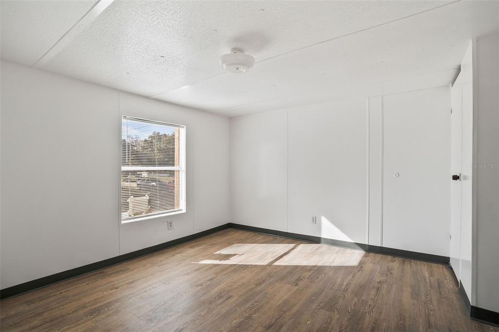 9342 Labelle Street New Port Richey, FL 34654 - Photo 7 of 20 an empty room with wooden floor and windows