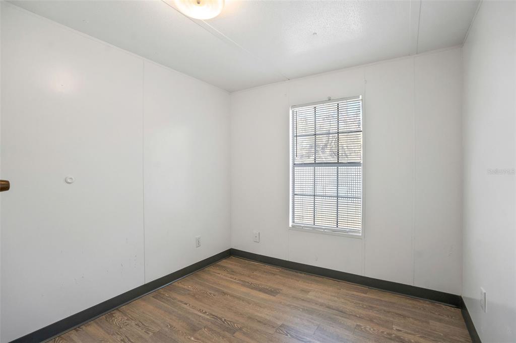 9342 Labelle Street New Port Richey, FL 34654 - Photo 8 of 20 an empty room with wooden floor and windows