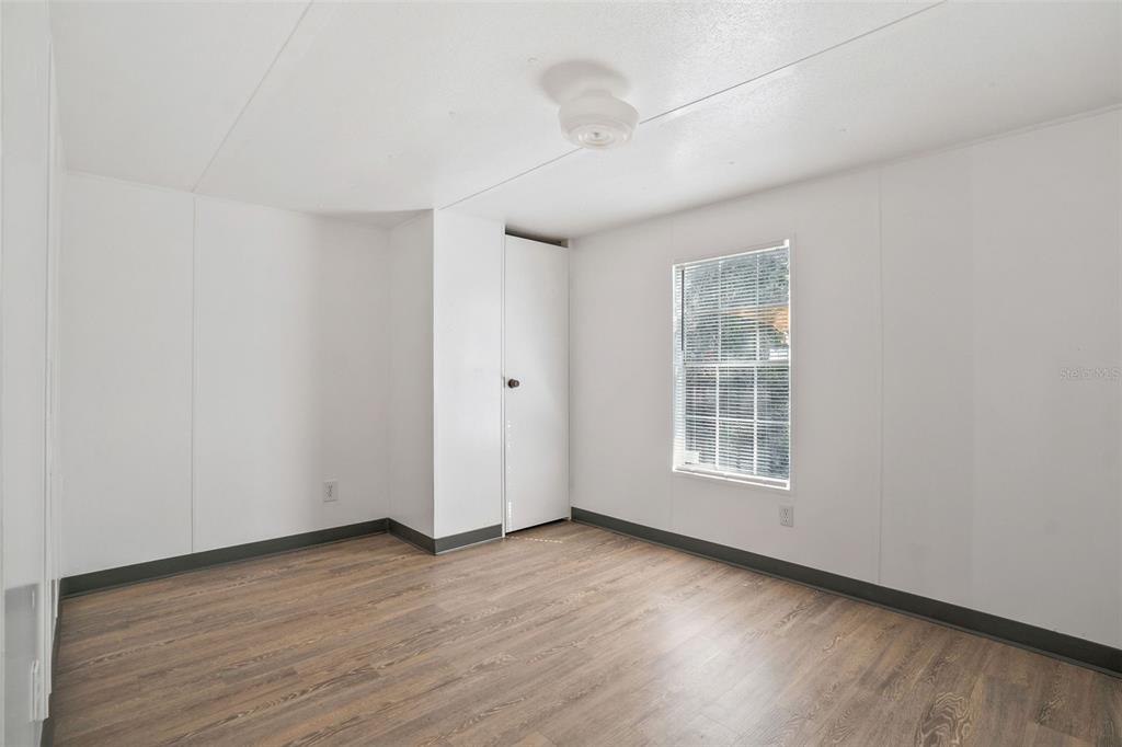 9342 Labelle Street New Port Richey, FL 34654 - Photo 9 of 20 an empty room with wooden floor and windows