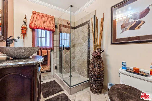 a bathroom with a granite countertop sink a mirror and shower