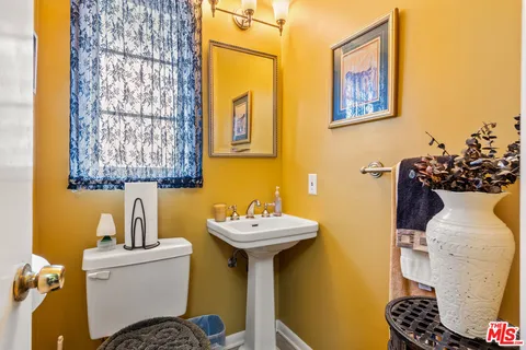 a bathroom with a sink and mirror with toilet