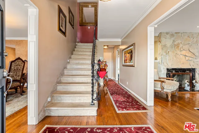 a view of entryway and hall with wooden floor