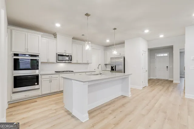 a large kitchen with cabinets and stainless steel appliances