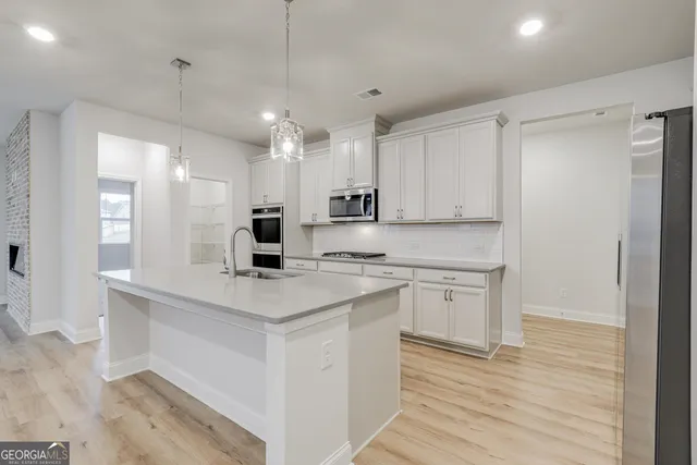 a kitchen with kitchen island sink stove and refrigerator