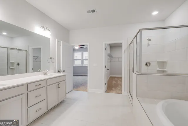 a bathroom with a double vanity sink toilet and shower