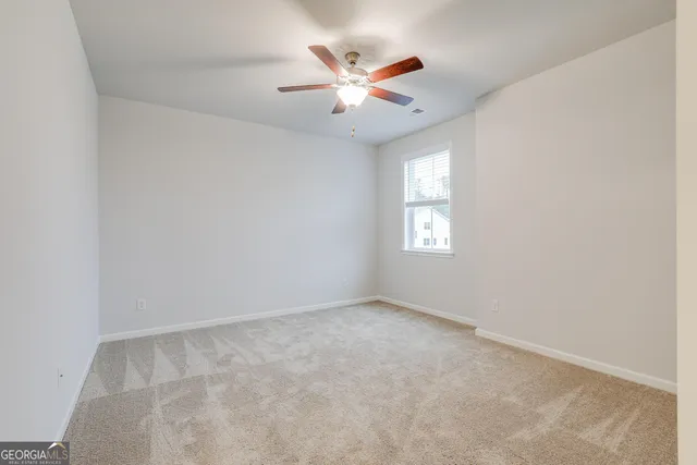 an empty room with closet and windows