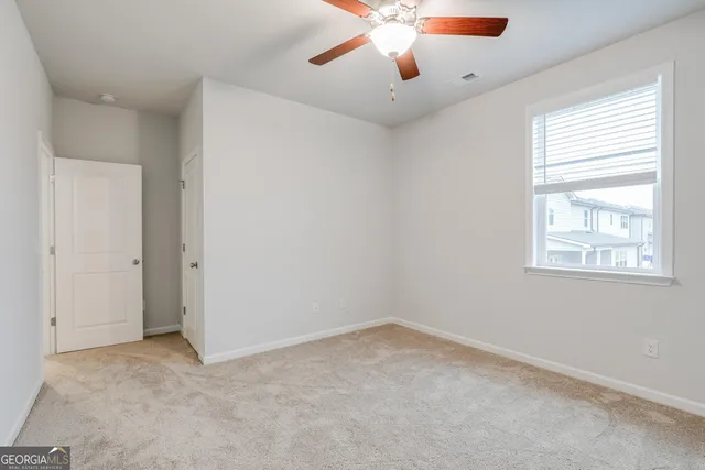 an empty room with closet and a chandelier fan