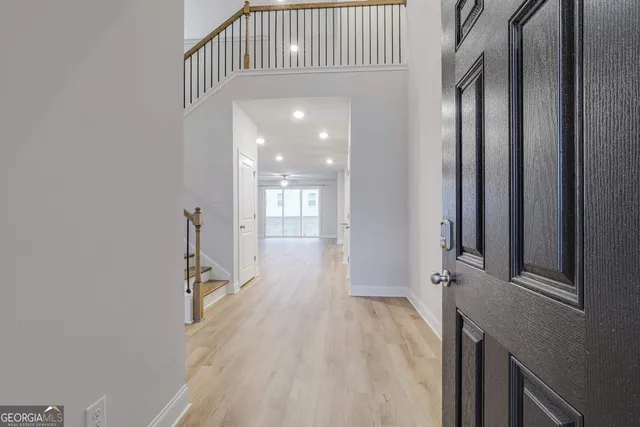 a view of a hallway with wooden floor and staircase