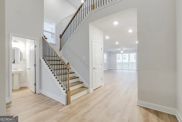 a view of a hallway with wooden floor and staircase