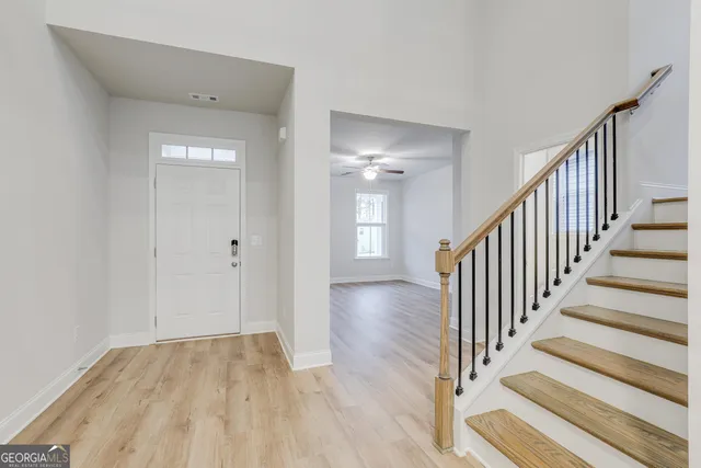 a view of a hallway with wooden floor and staircase