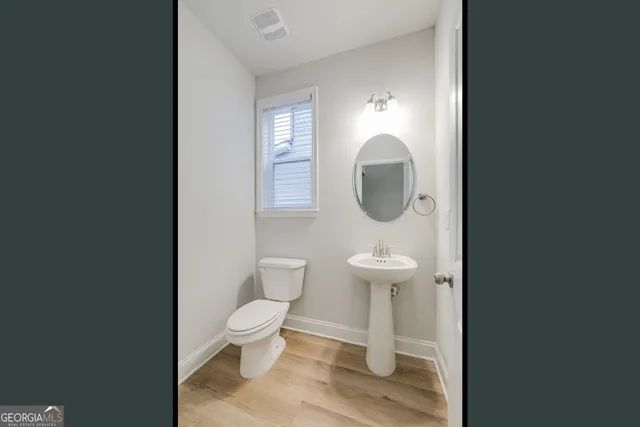 a bathroom with a toilet a sink and a mirror