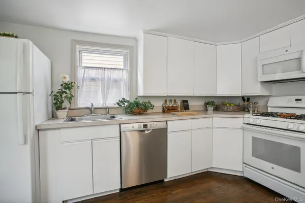 a kitchen with white cabinets and white appliances