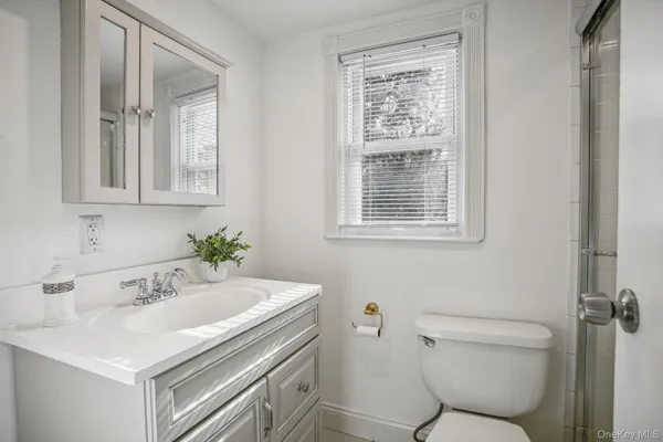 a bathroom with a sink a toilet and a window