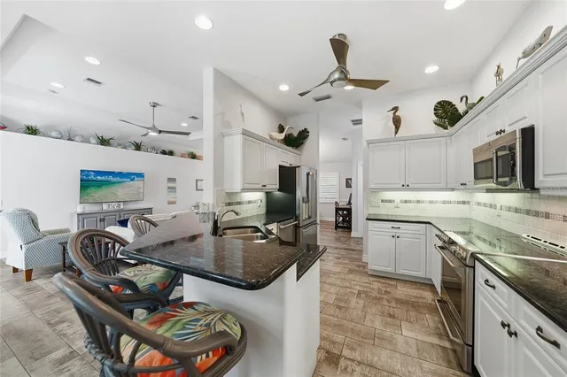 a kitchen with stainless steel appliances granite countertop a sink and a stove