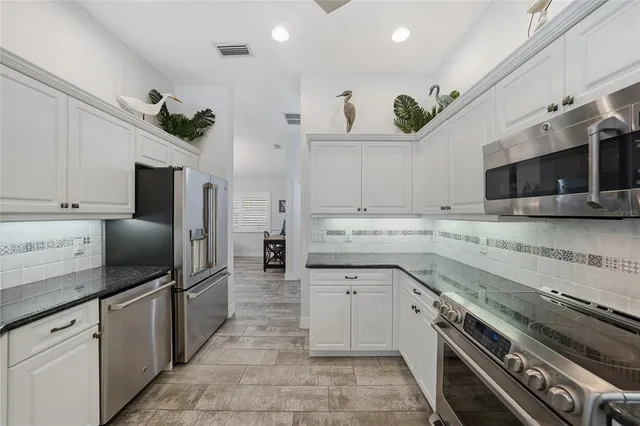 a kitchen with a sink stainless steel appliances and cabinets