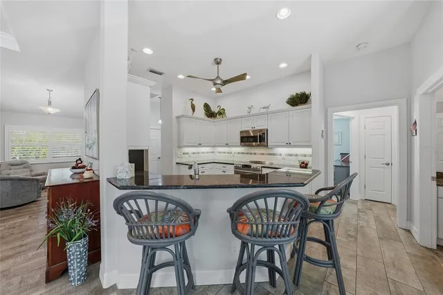 a kitchen with stainless steel appliances a dining table chairs stove and kitchen view