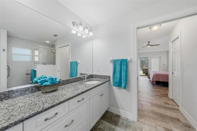 a bathroom with a granite countertop sink and a mirror