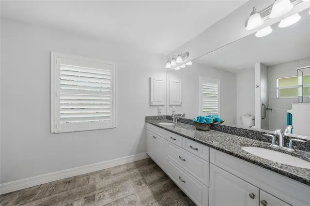 a bathroom with double vanity and a mirror