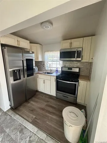 a kitchen with stainless steel appliances a stove a microwave a sink a refrigerator and cabinets