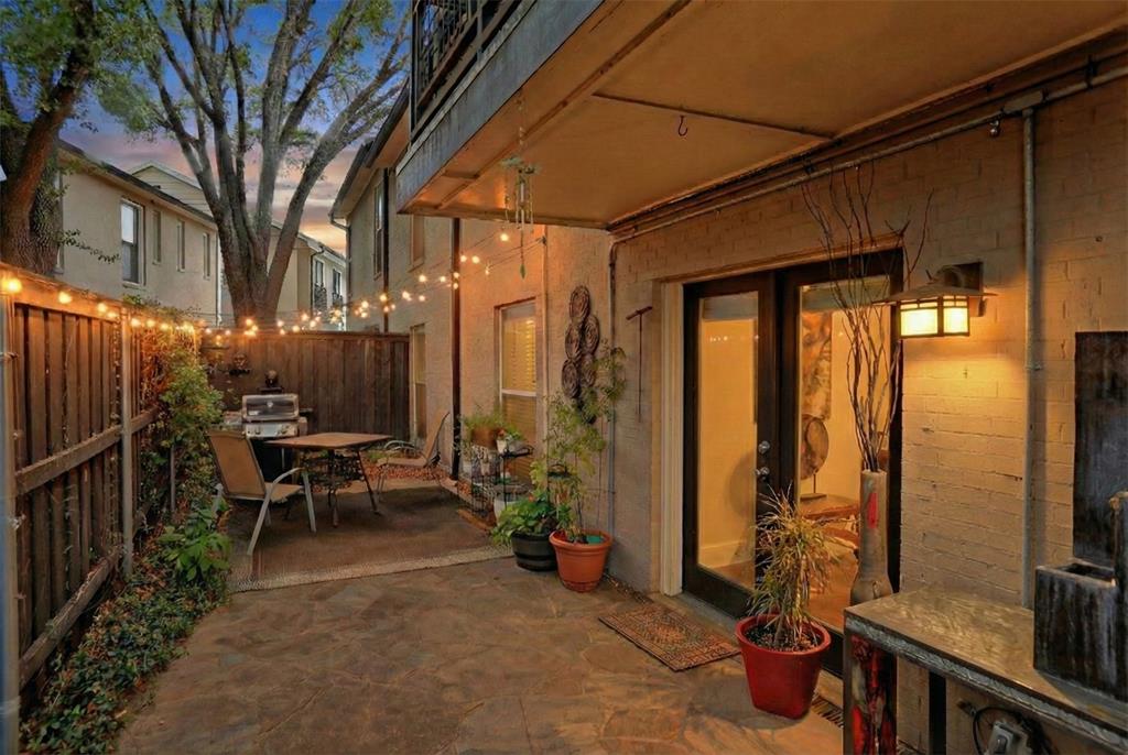 7736 Meadow Road, Unit 102 Dallas, TX 75230 - Photo 2 of 25 a view of a patio with table and chairs and wooden fence
