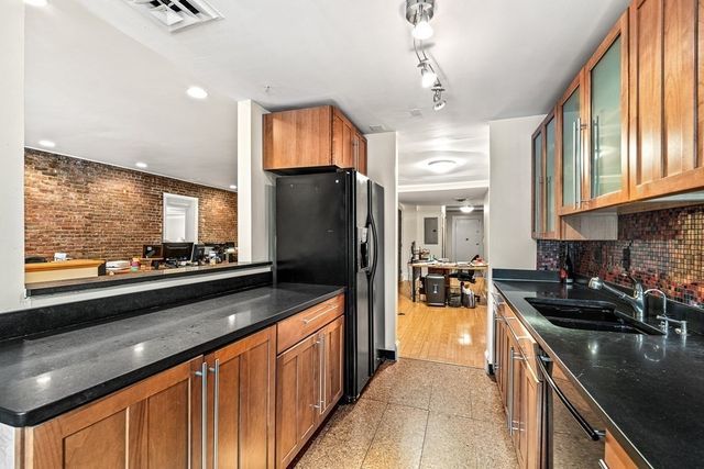 a kitchen with stainless steel appliances granite countertop a sink stove and refrigerator