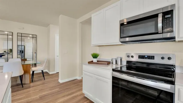 a kitchen with stainless steel appliances a stove a microwave a sink and cabinets