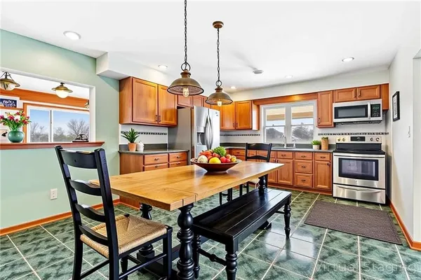 a outdoor kitchen with a stove a sink and a dining table with chairs