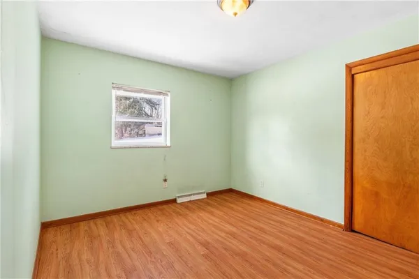 an empty room with wooden floor and a window