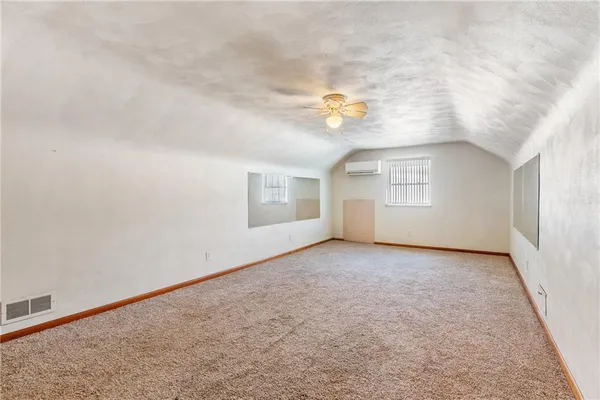 an empty room with windows & cabinet