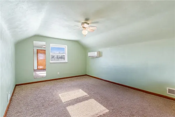 an empty room with windows and ceiling fan