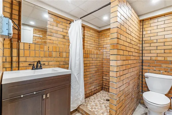 a bathroom with a sink a toilet and shower