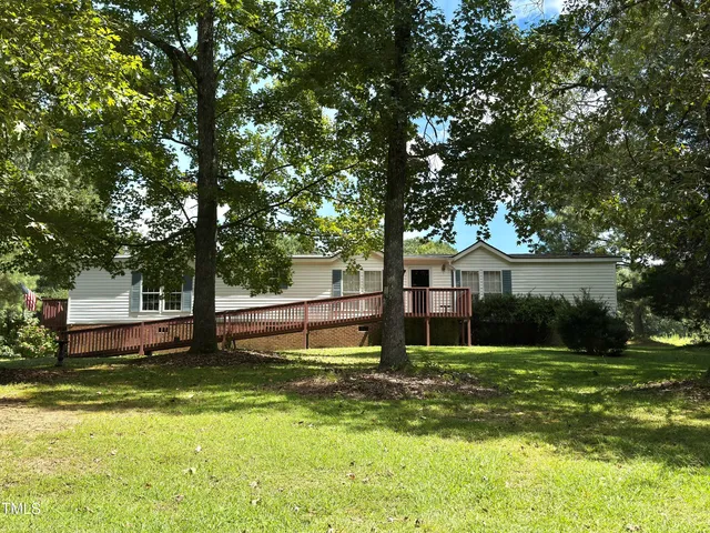a view of a house with a swimming pool and a large tree