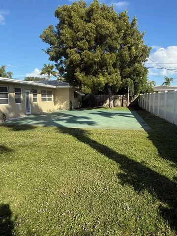 a view of a house with a big yard and a large tree