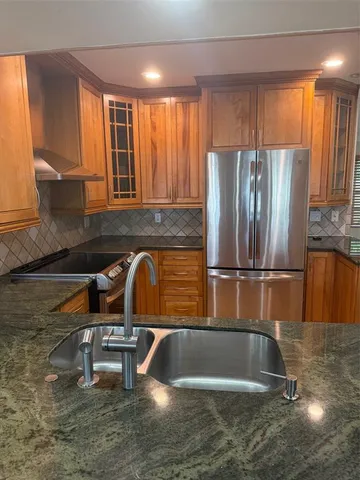 a view of a kitchen with wooden floor and electronic appliances