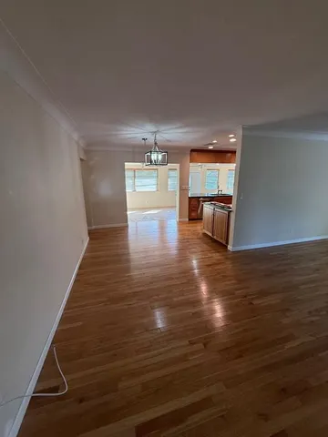 a view of empty room with kitchen and window