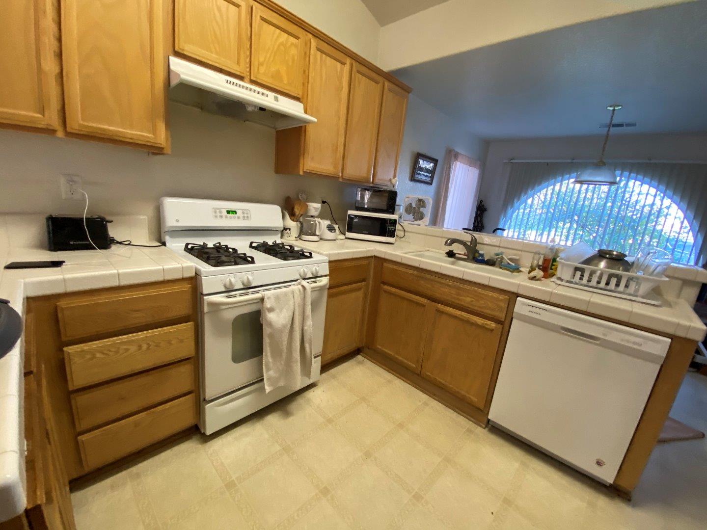 1431 Cardinal Street Los Banos, CA 93635 - Photo 5 of 10 a kitchen with a stove sink and cabinets