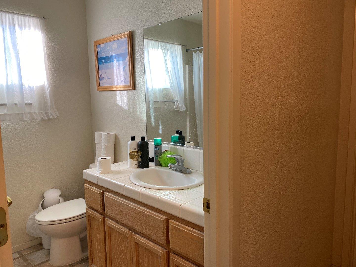 1431 Cardinal Street Los Banos, CA 93635 - Photo 9 of 10 a bathroom with a sink a toilet and mirror