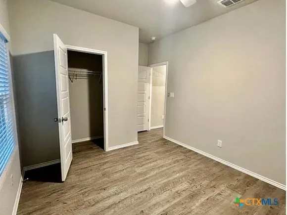 an empty room with wooden floor and closet