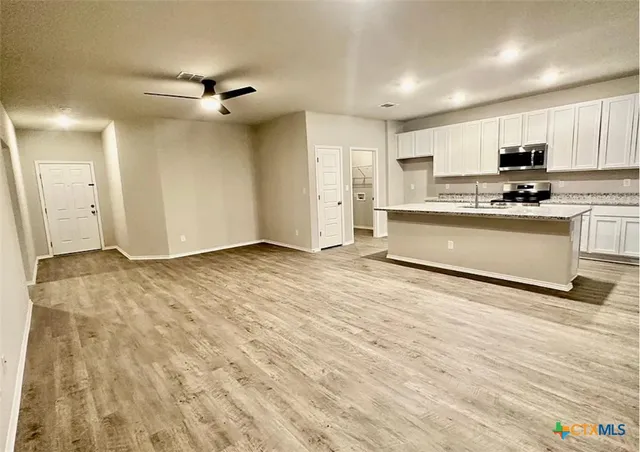 a view of kitchen with stainless steel appliances cabinets and wooden floor