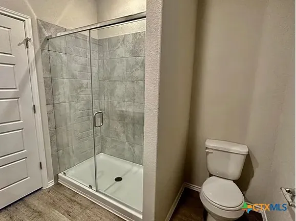 a bathroom with a toilet and a shower