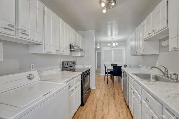 a kitchen with a sink a stove and cabinets