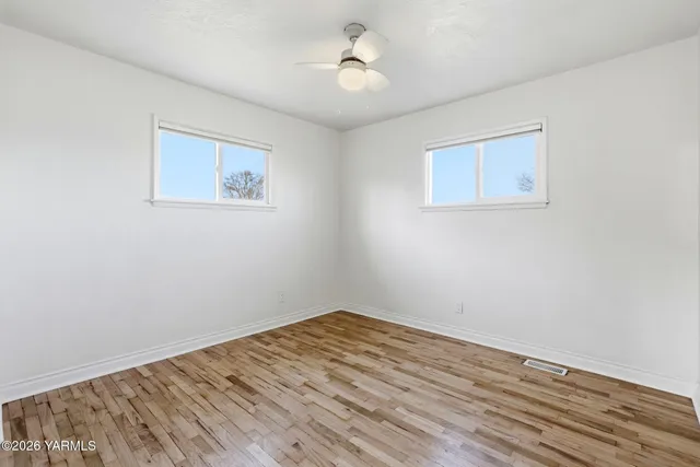 a view of empty room with wooden floor