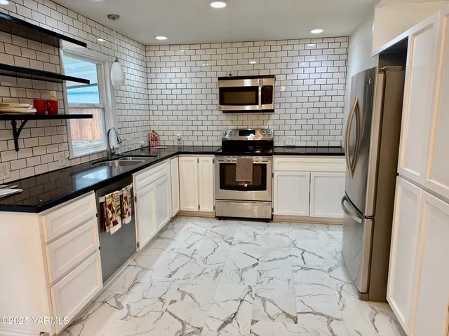 a kitchen with stainless steel appliances a refrigerator sink and microwave