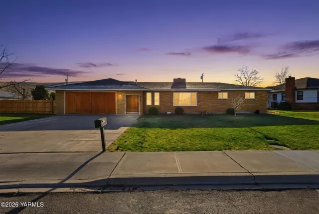 a front view of a house with a yard and a garage