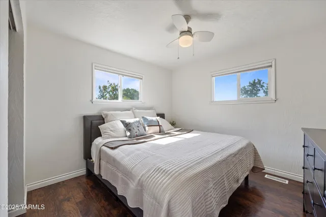 a bedroom with bed and a painting on the wall