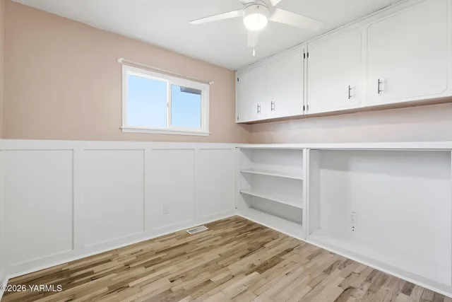 a view of an empty room with closet and wooden floor